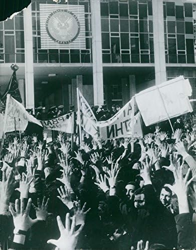Гроздобер фотографија на луѓе собрани на страната на улицата, кревајќи ги рацете, држејќи транспаренти, со полицајци преку улицата, март 1964