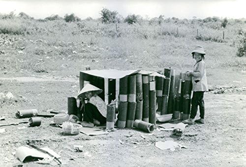 Гроздобер фотографија на виетнамски локални жители кои собираат празни лушпи од топови.